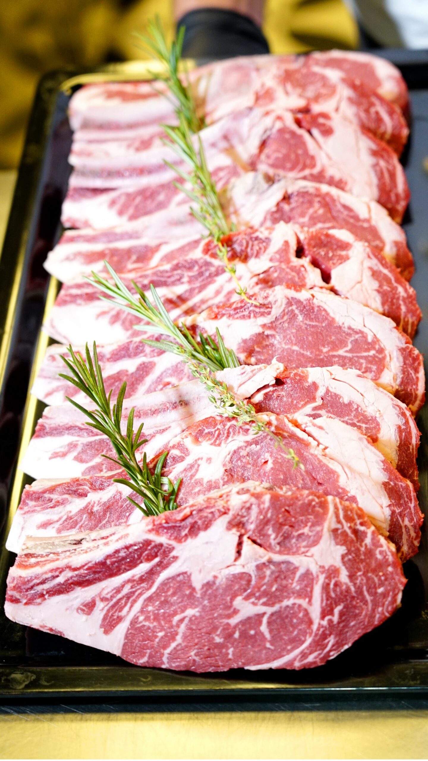 Filetes de ternera frescos y crudos con vetas de grasa y unas ramas de romero