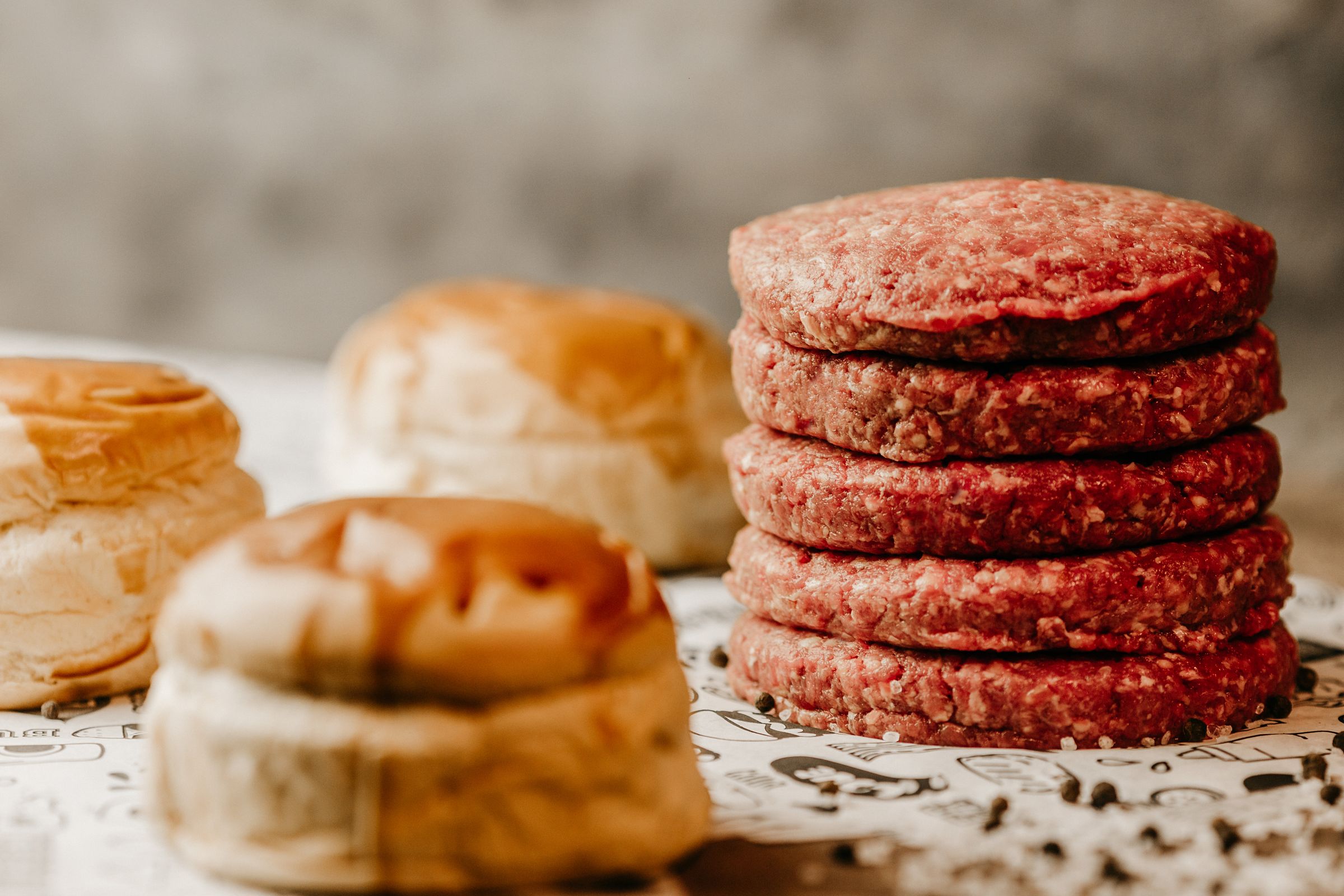 Hamburguesas de vaca frescas y crudas apiladas antes de cocinar
