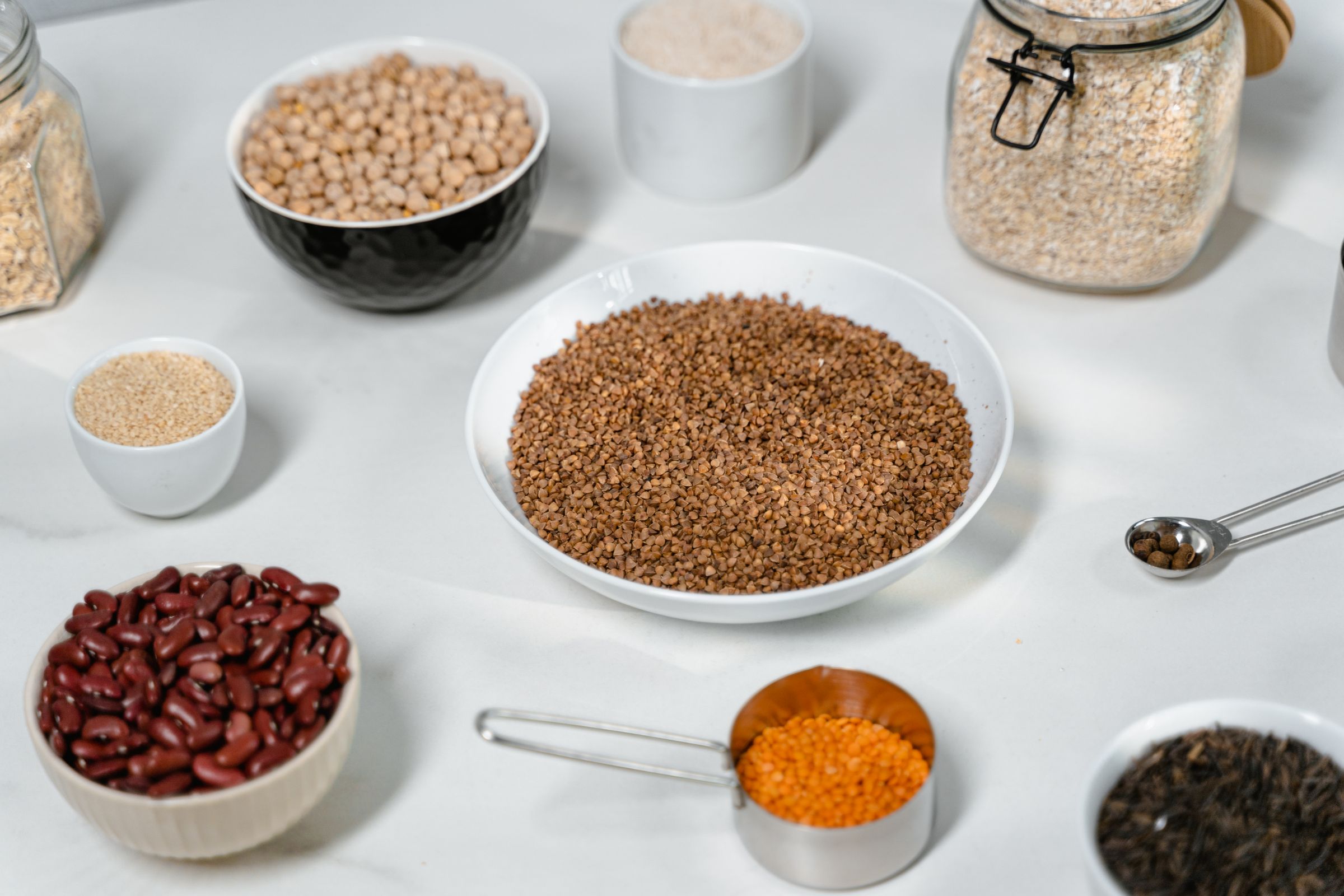 Legumbres, cereales y alimentos secos organizados en cuencos y tarros