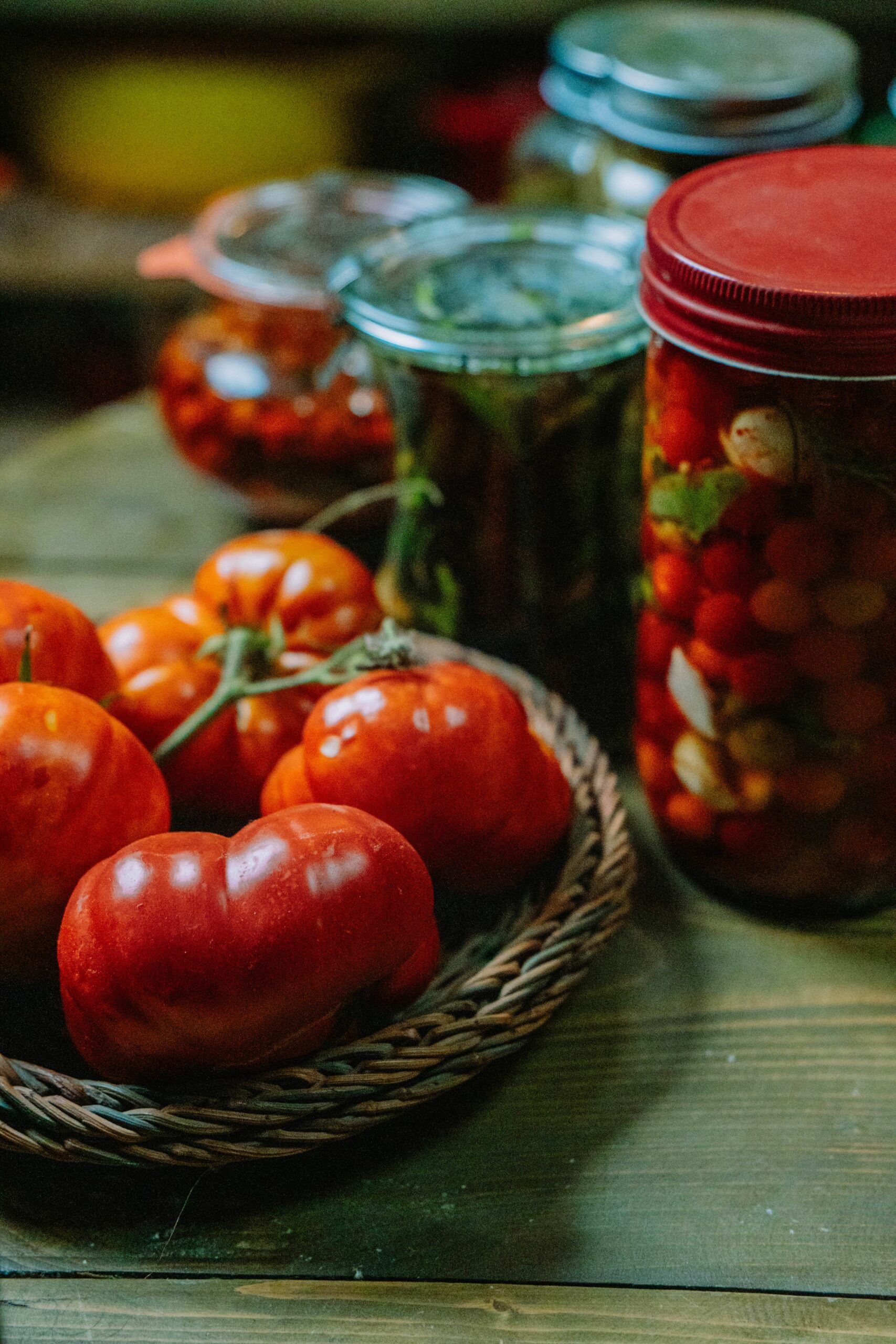 Tomates frescos junto a verduras en conserva sobre una mesa