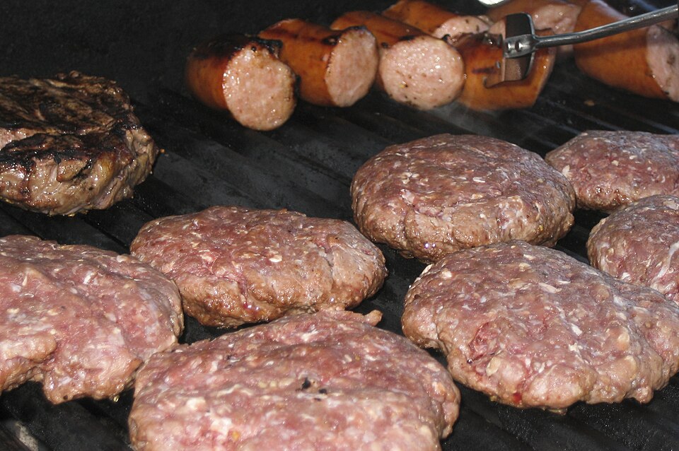 Piezas de carne genérica cocinándose sobre una parrilla de barbacoa